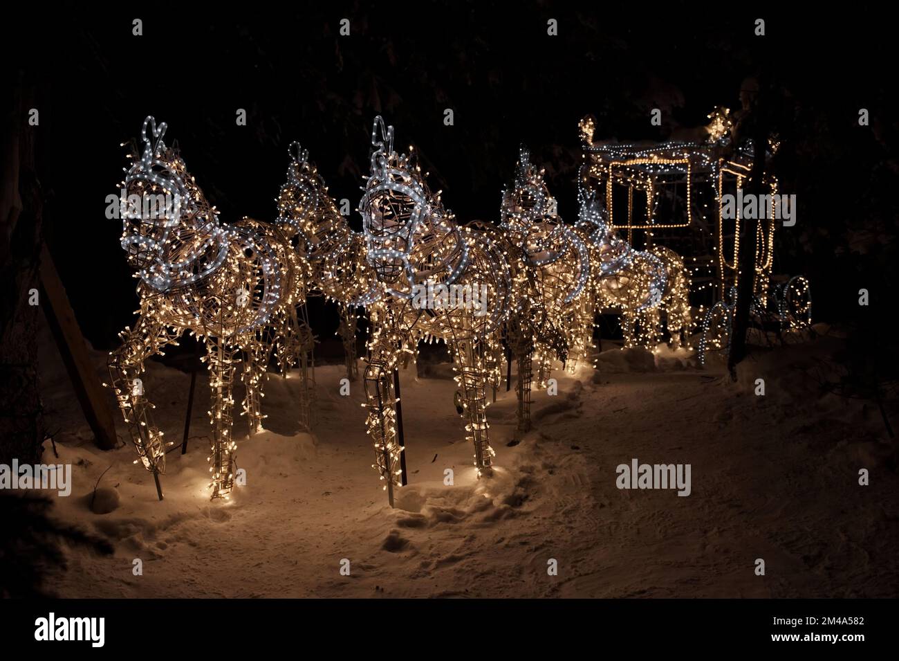 Figure de calèche avec des chevaux illuminés de lumières de Noël contre le paysage de nuit, Autriche Banque D'Images