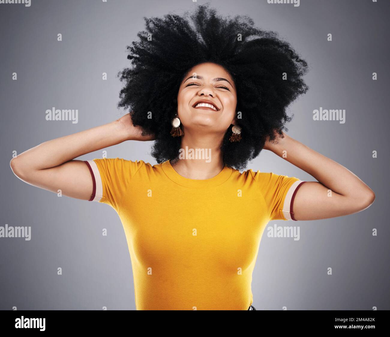 Elle lui donne des cheveux fabuleux. Photo en studio d'une jeune femme attrayante posant sur un fond gris. Banque D'Images