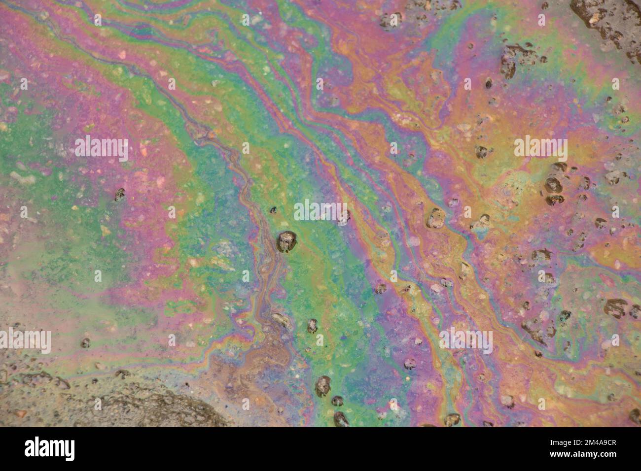 de l'essence s'est répandue sur la route dans une flaque d'eau colorée Banque D'Images