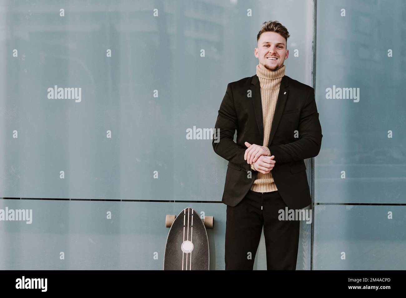 Portrait d'un homme élégant avec une planche à roulettes Banque D'Images