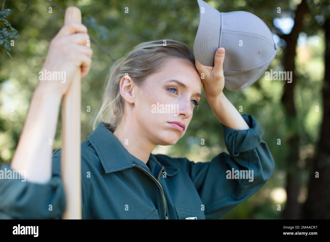 femme fatiguée femme jardinier tenant le râteau Banque D'Images