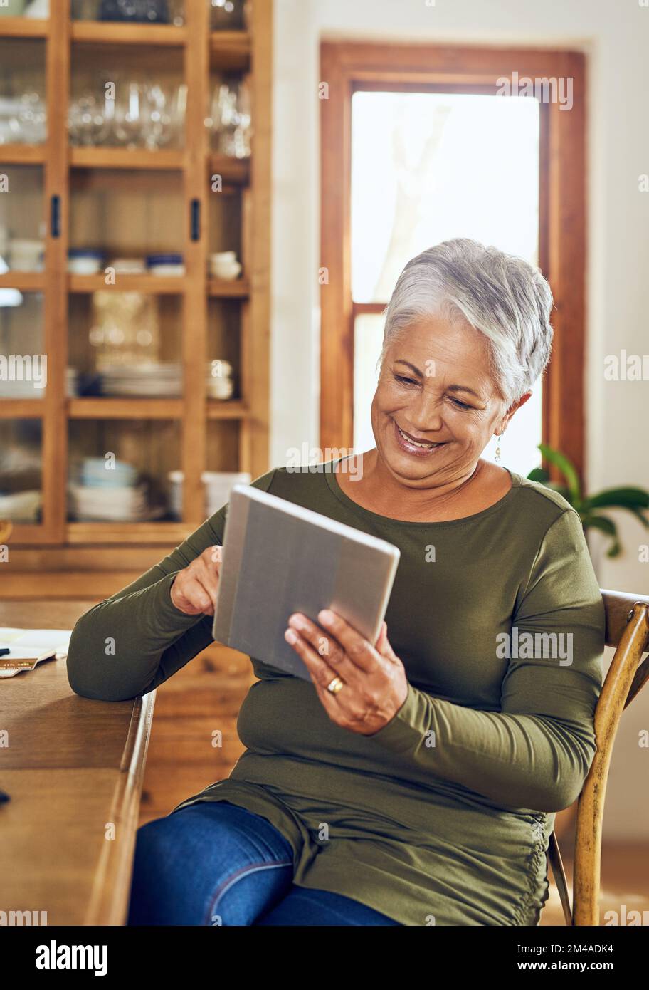 Il n'est pas étranger au monde numérique. une femme mûre utilisant une tablette numérique à la maison. Banque D'Images