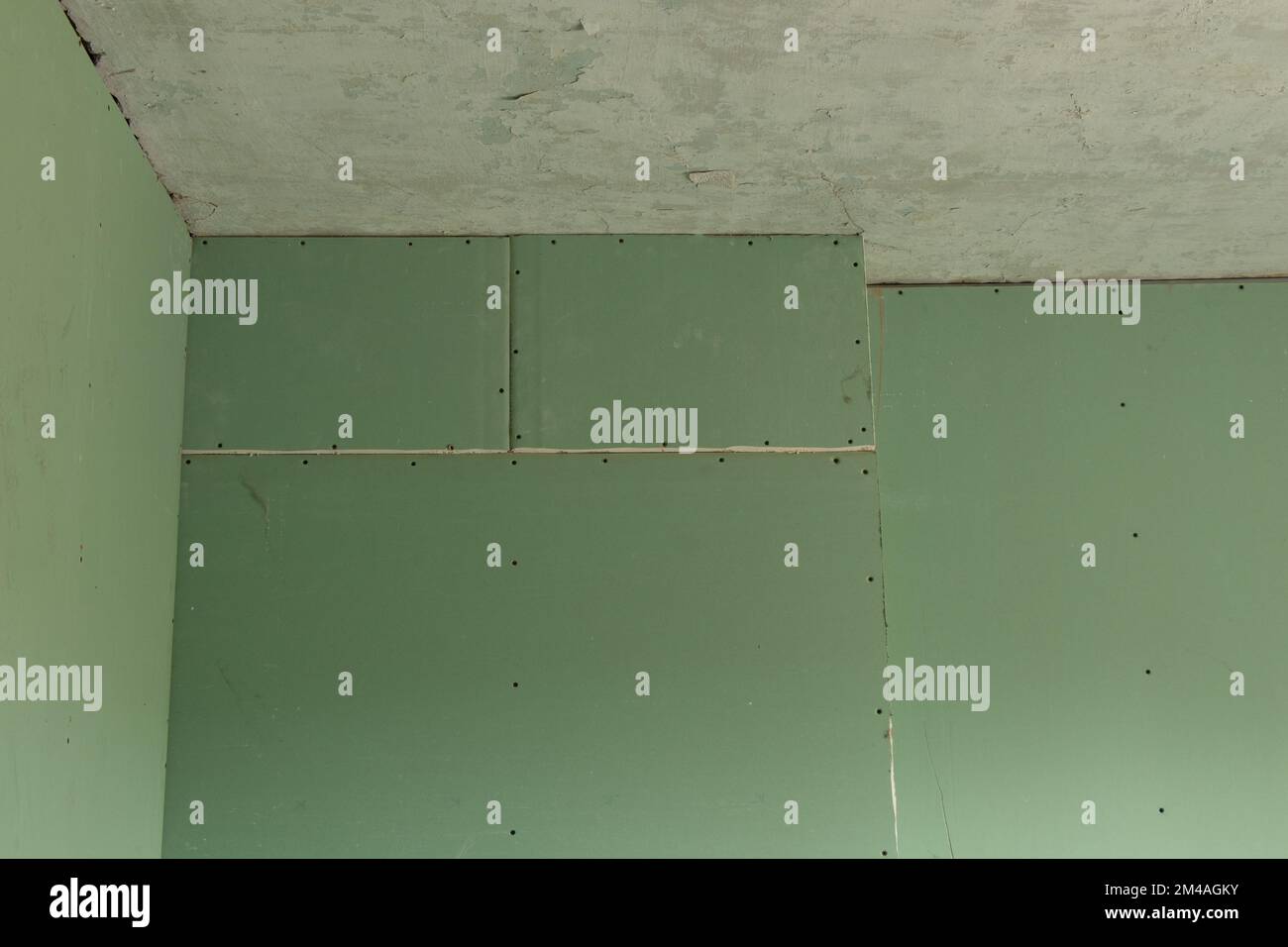 plaque de plâtre verte sur le mur, réparation de la salle Banque D'Images