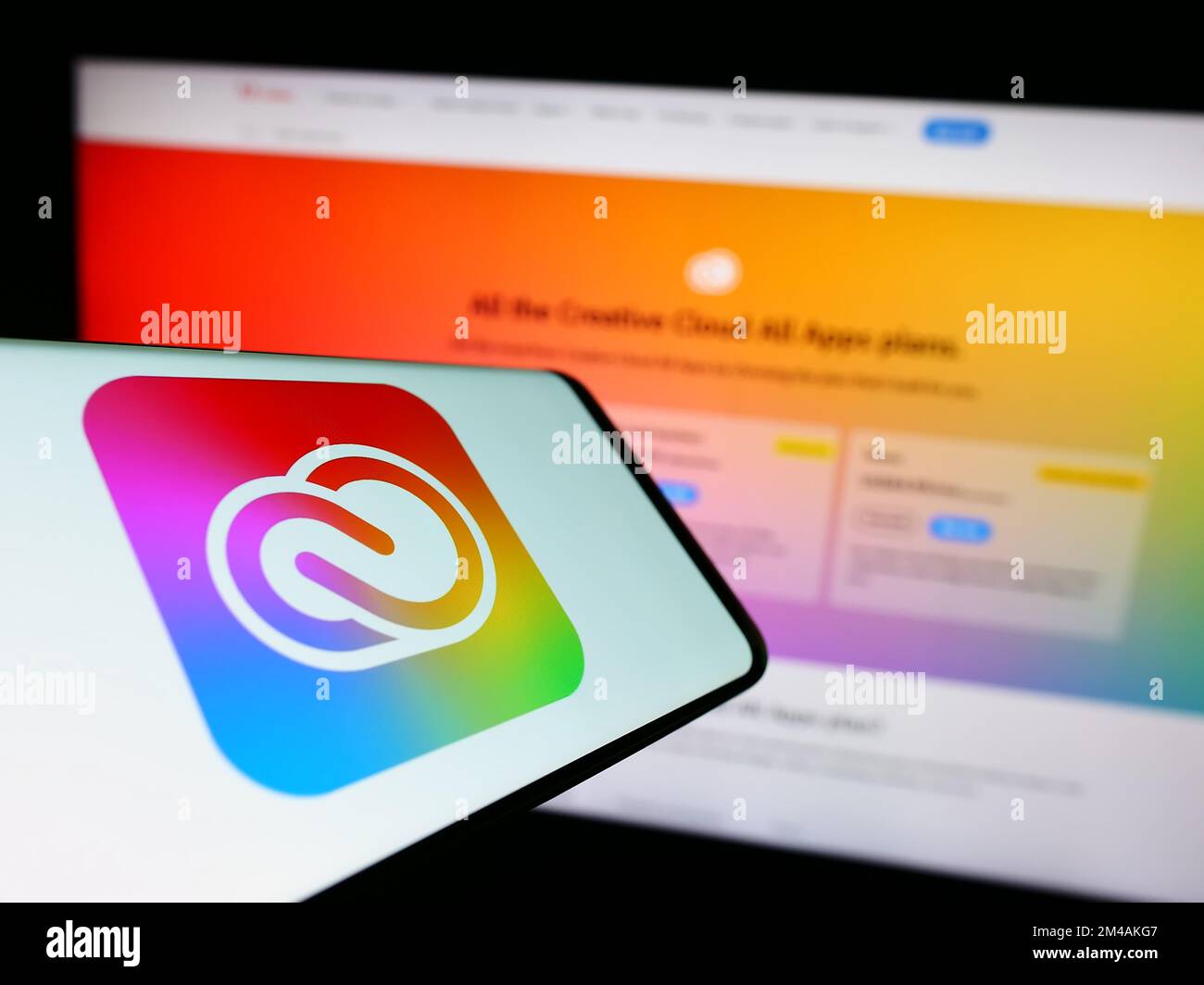 Smartphone avec logo du logiciel Adobe Creative Cloud à l'écran, devant le site Web de l'entreprise. Effectuez la mise au point à droite de l'écran du téléphone. Banque D'Images
