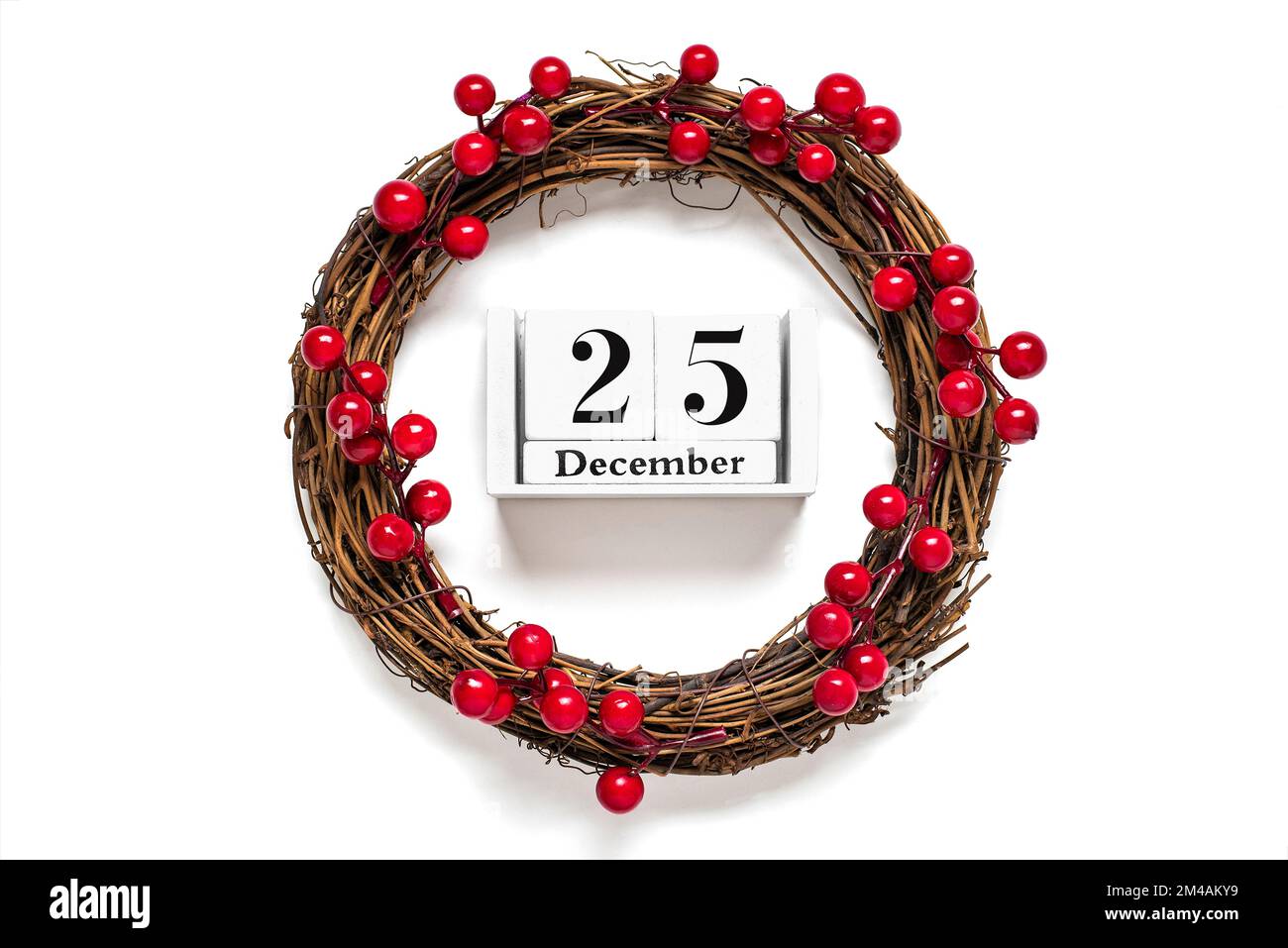 Couronne de Noël décorée de baies rouges, calendrier en bois date du 25 décembre isolé sur fond blanc concept de préparation de Noël, atmosphère Banque D'Images