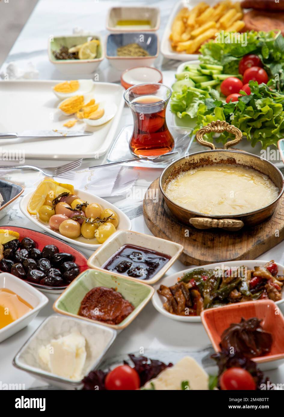 Petit-déjeuner turc traditionnel servi avec du thé turc traditionnel sur une table en marbre Banque D'Images