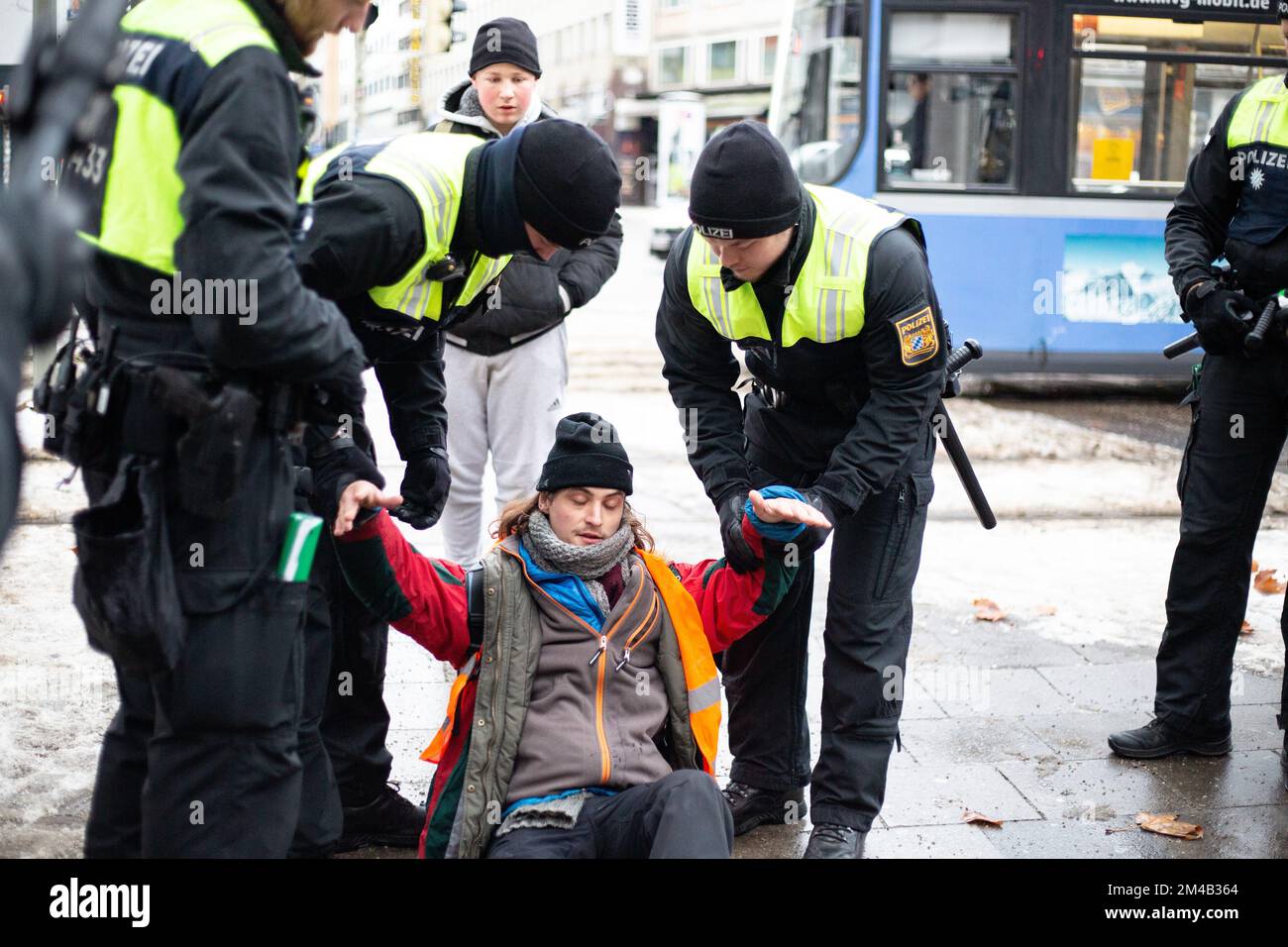 Munich, Allemagne. 20th décembre 2022. Quatre activistes de la dernière génération ont bloqué la Sonnenstraße à Munich, Allemagne 20 décembre 2022, malgré une ordonnance du KVR contre les blocs de colle. À l'avance, l'action a été officiellement annoncée, c'est pourquoi beaucoup de policiers étaient sur place et ont arrêté 6 autres activistes avant qu'ils ne puissent bloquer la rue. La dernière génération présente un billet de 9 euros et une limite de vitesse de 100 km/h sur les autoroutes. (Photo par Alexander Pohl/Sipa USA) crédit: SIPA USA/Alay Live News Banque D'Images