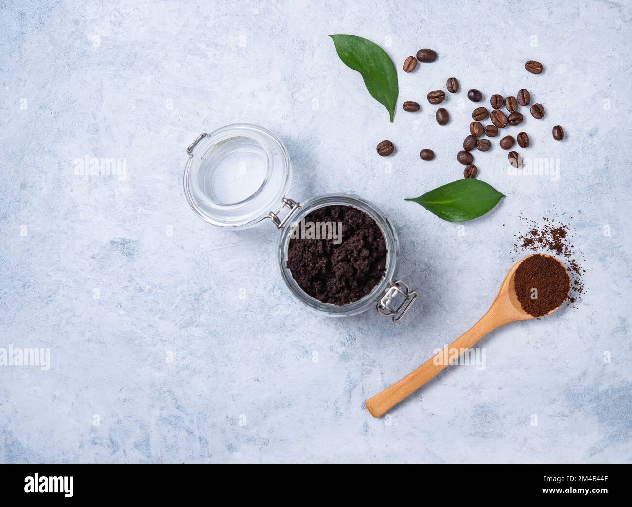 Concept à base d'ingrédients naturels pour un gommage à la maison avec grains de café et poudre de café sur fond bleu. Soins du corps pour la peau. Vue de dessus et Banque D'Images