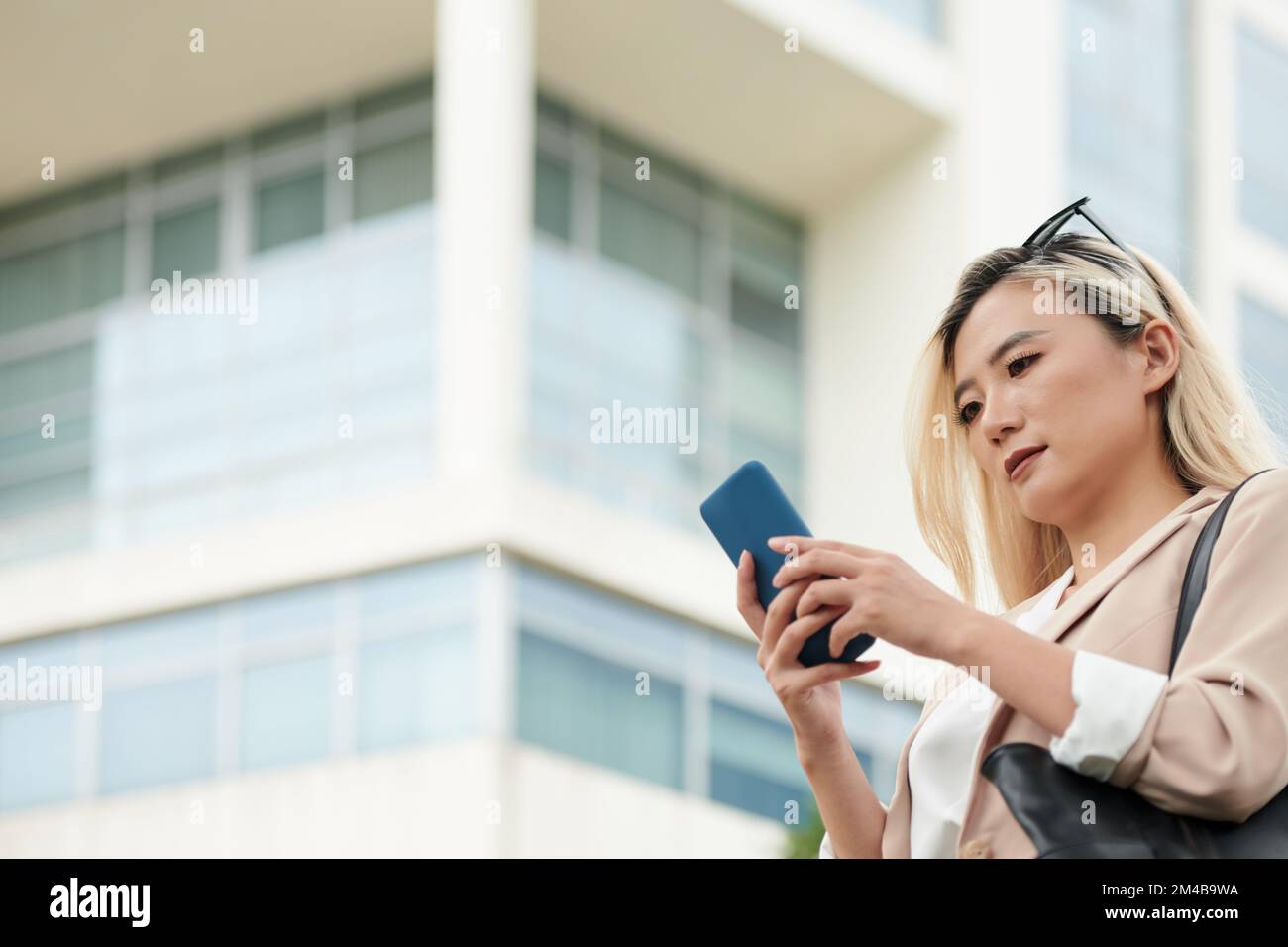 Femme d'affaires qui répond aux messages texte de son collègue Banque D'Images