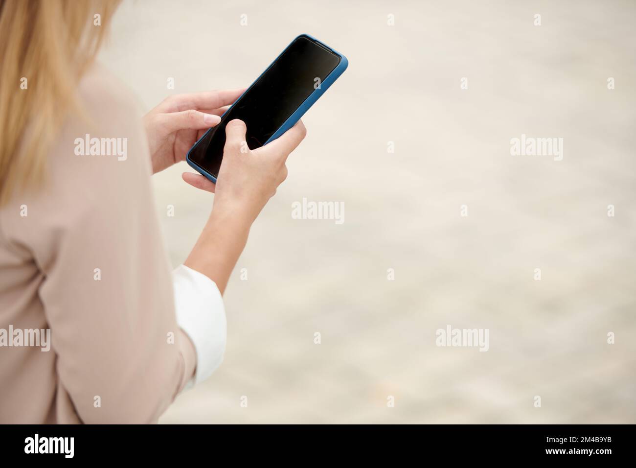 Mains d'une femme entrepreneur qui répond aux messages sur un téléphone de sartphone Banque D'Images