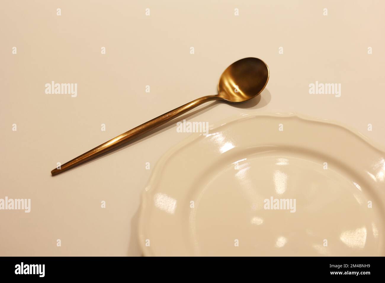 Une cuillère en laiton coréen avec un plat blanc vide sur la table, la  cuillère sur le plat Photo Stock - Alamy