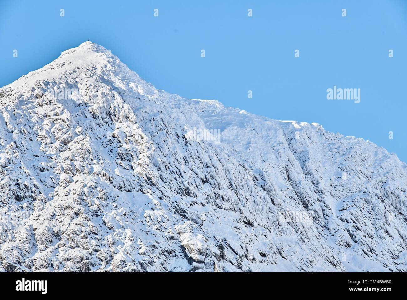 Une personne solitaire au sommet du mont Snowdon, par une belle journée d'hiver. Banque D'Images