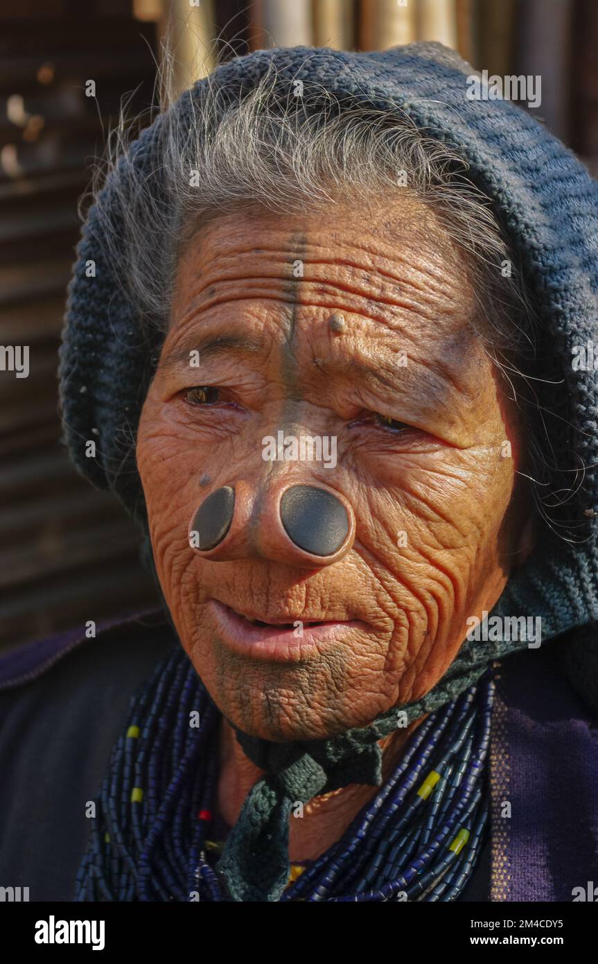 Ziro, Arunachal Pradesh, Inde - 02 19 2013 : Portrait de la vieille femme tribale d'Apatani avec des tatouages faciaux traditionnels et des bouchons de nez portant une casquette bleue Banque D'Images