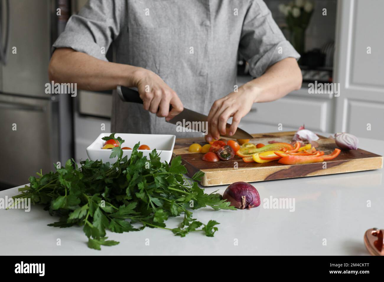 Couper les tomates en cuisine avec du persil Banque D'Images