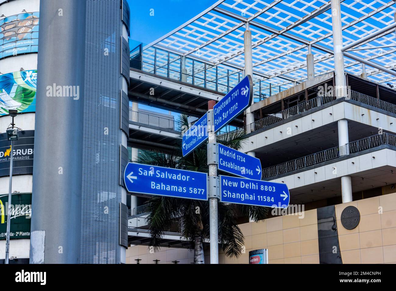 Un panneau devant un centre commercial à las Palmas, Gran Canaria, avec des indications et des kilomètres pour Shanghai, New Delhi, les Bahamas et Capetown. Banque D'Images
