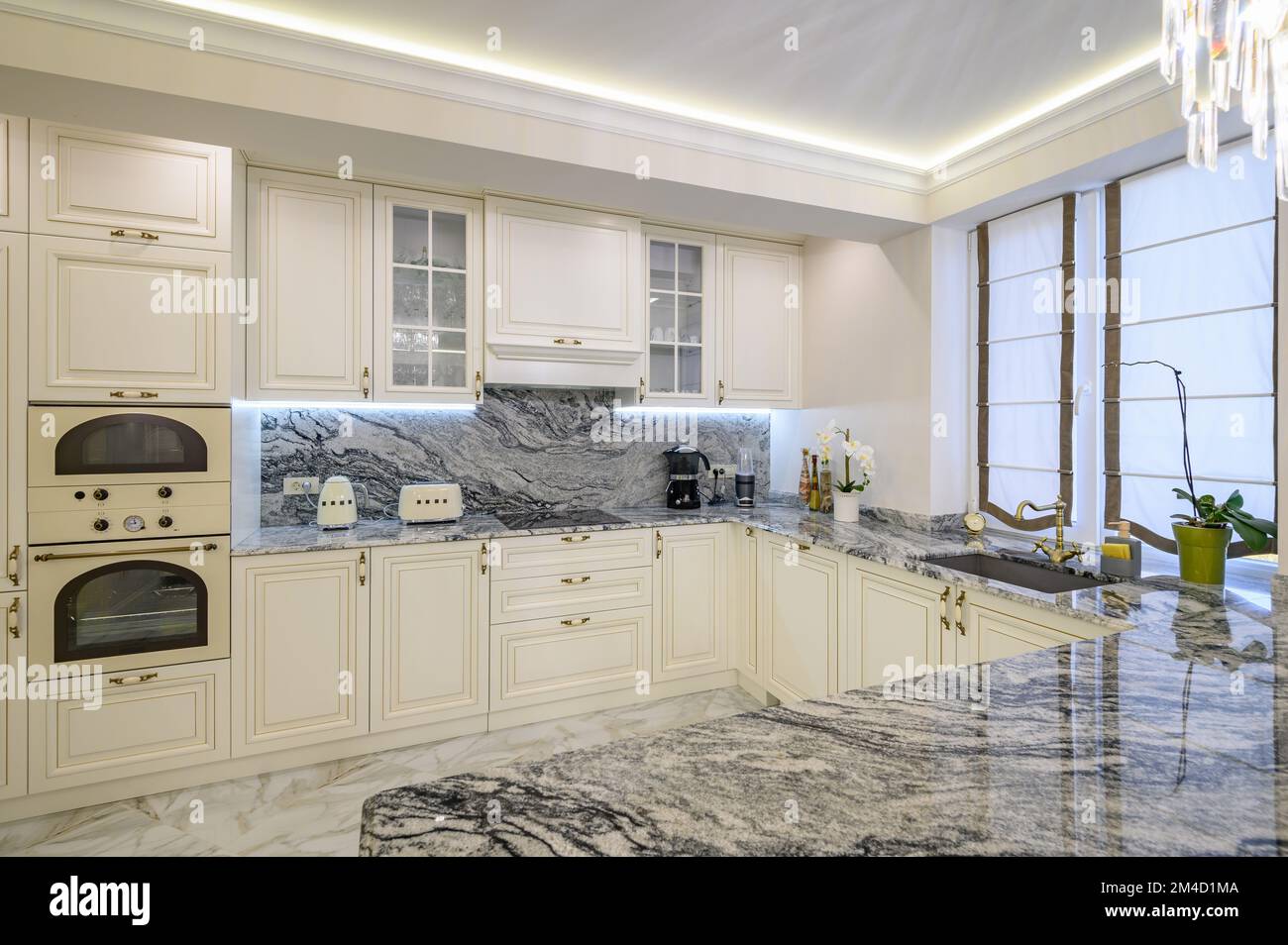 Cuisine classique couleur crème avec îlot utilisé comme salle à manger dans l'appartement studio Banque D'Images