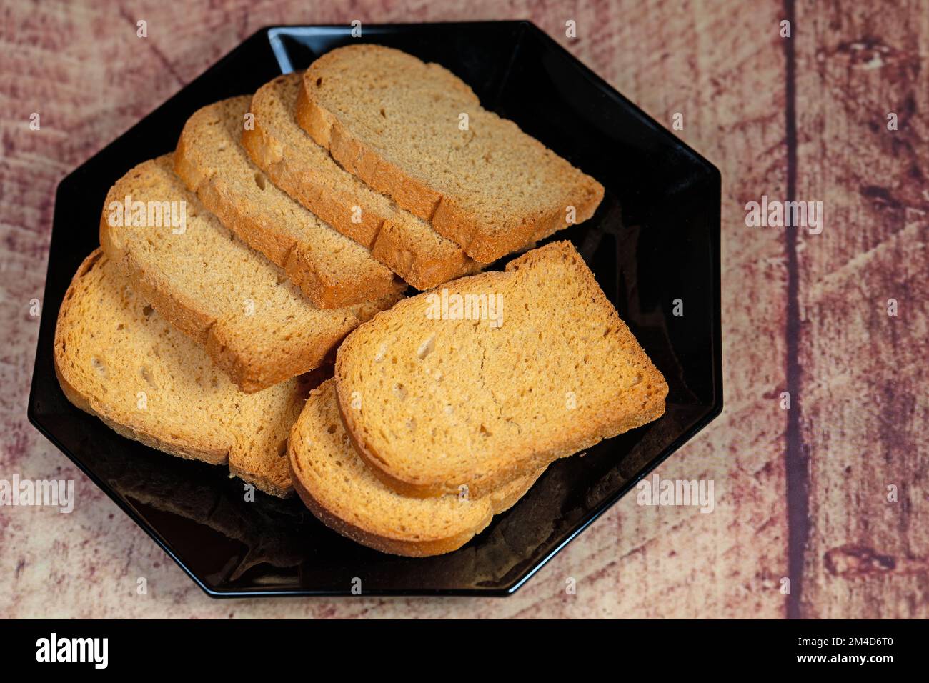 Des tranches de Rusk sur une assiette noire Banque D'Images