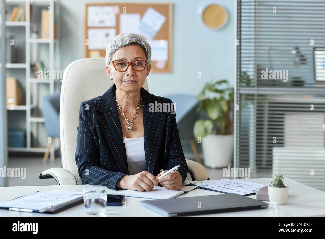 Portrait d'une femme âgée en tant que patron féminin assis au bureau et regardant l'appareil photo, l'espace de copie Banque D'Images