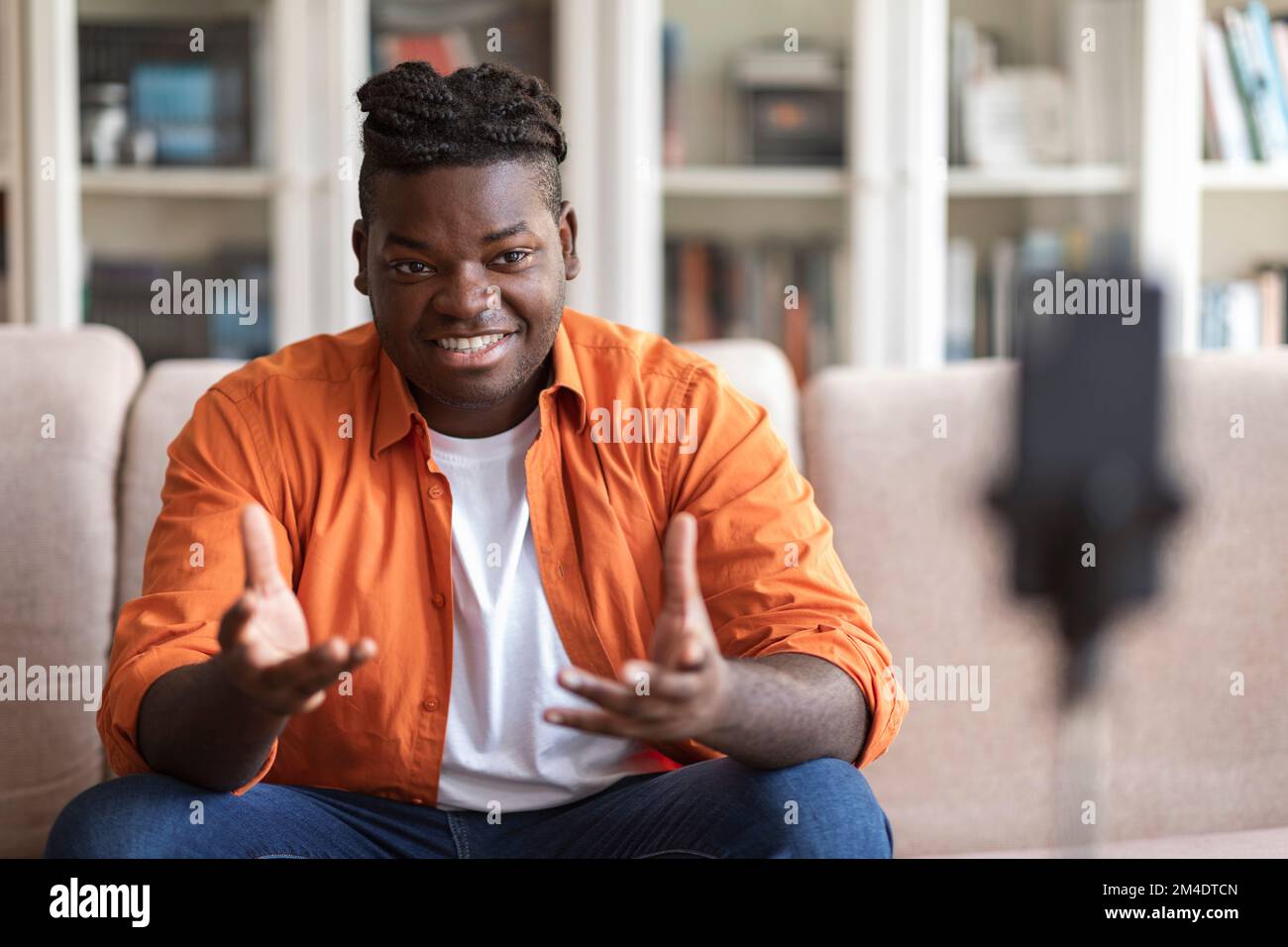 Jeune homme africain blogger dans des vêtements décontractés streaming vidéo en ligne Banque D'Images