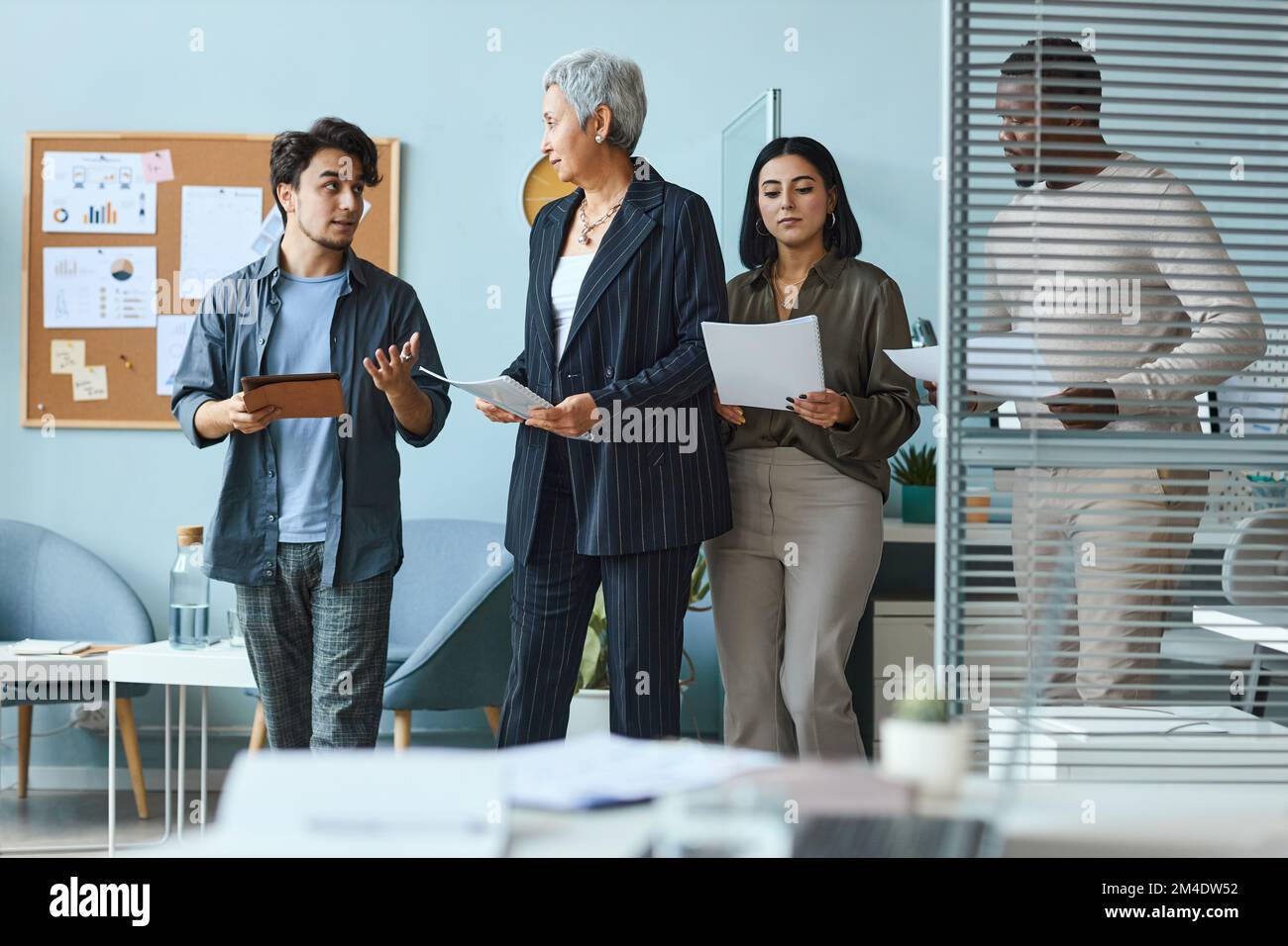 Groupe multiethnique de gens d'affaires avec une femme patron pendant le processus de travail au bureau Banque D'Images