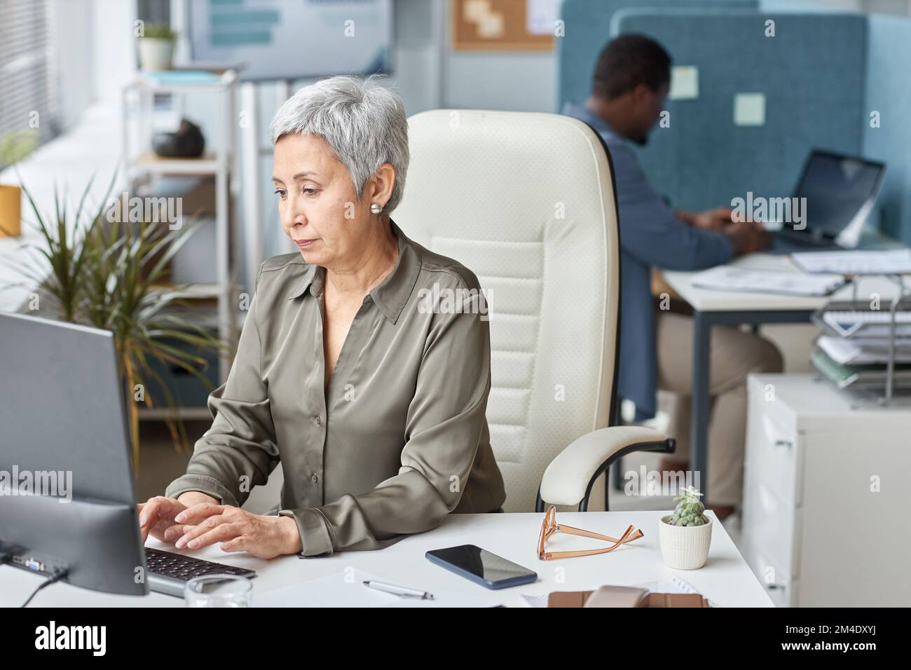 Portrait d'une femme d'affaires âgée élégante utilisant un ordinateur au bureau en tant que patron féminin Banque D'Images