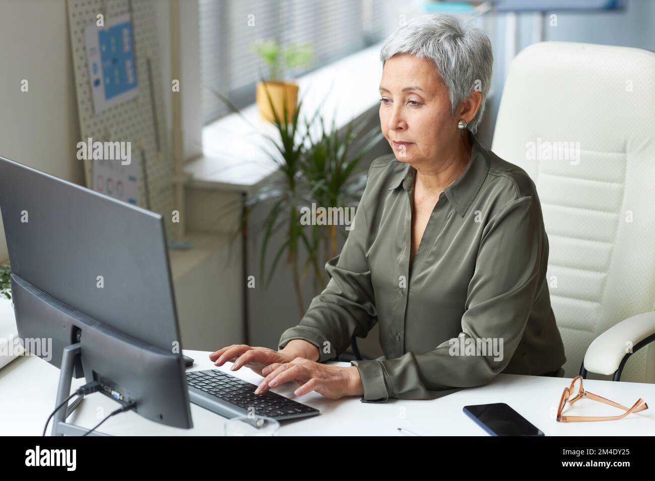 Portrait d'une femme cadre sur le lieu de travail, dactylographiant au clavier d'ordinateur Banque D'Images