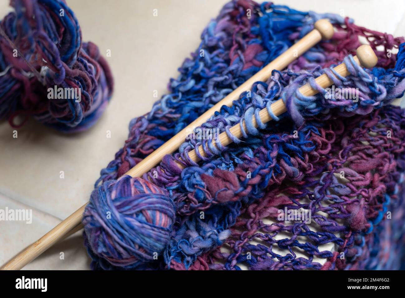 Gros plan sur les aiguilles à tricoter en bois et le fil de laine coloré Banque D'Images