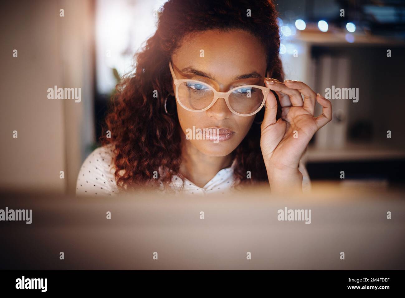 Elle fait preuve de dévouement tout au long de tout. une jeune femme d'affaires travaillant sur un ordinateur dans un bureau la nuit. Banque D'Images