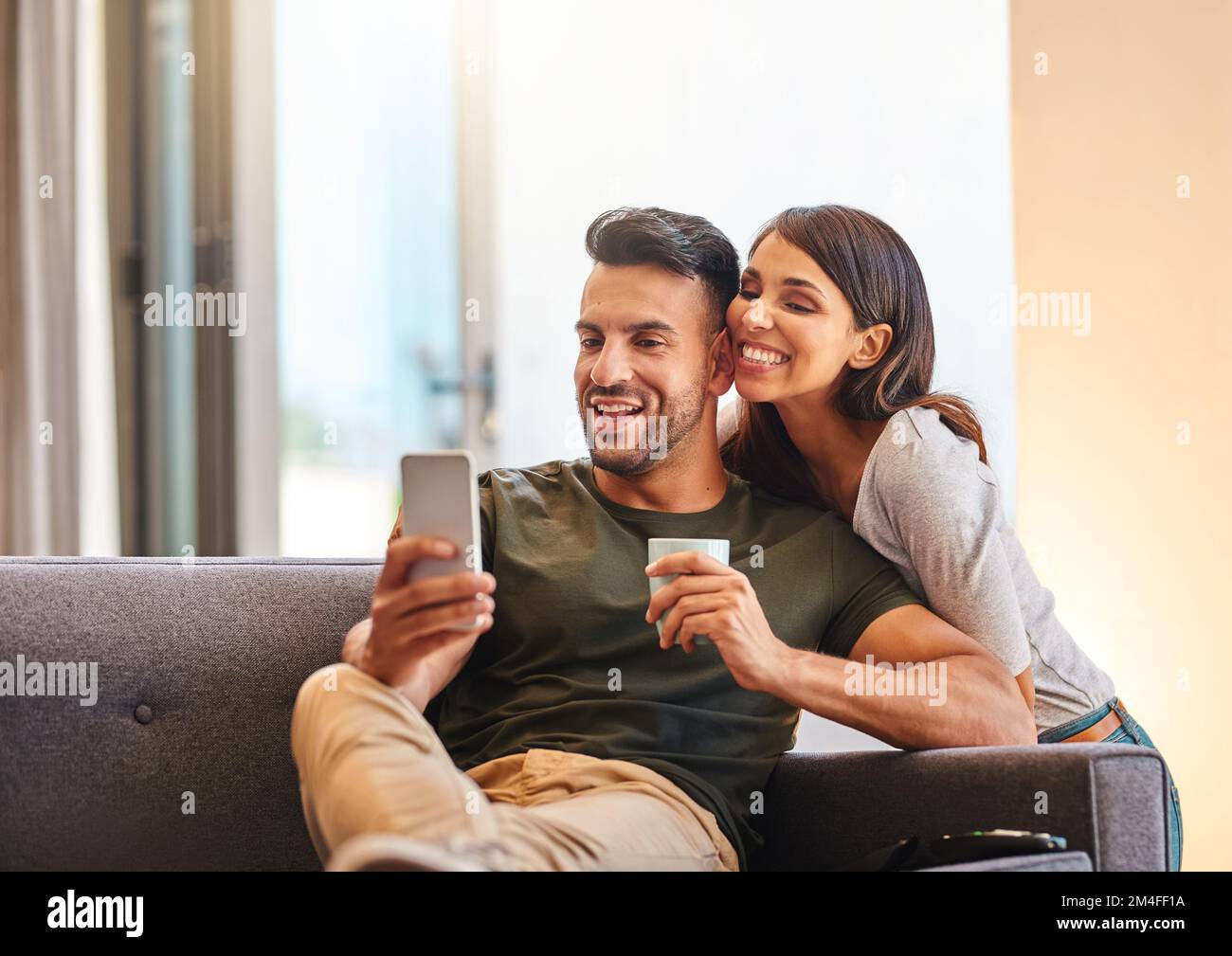 Ce sera mon nouvel écran de fond d'écran. un jeune couple qui rassemble des selfies à la maison. Banque D'Images