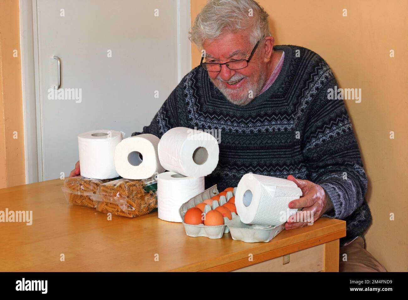 Homme âgé ou âgé très heureux d'avoir une arge de rouleaux de toilettes. Collecte des rouleaux de toilettes en cas de pénurie, possessif à leur sujet. Banque D'Images