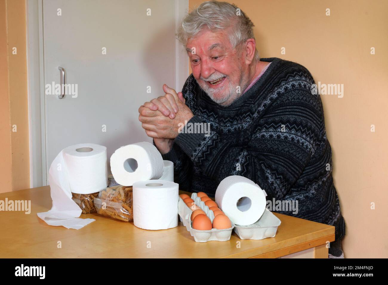 Homme âgé ou âgé très heureux d'avoir une arge de rouleaux de toilettes. Collecte des rouleaux de toilettes en cas de pénurie, possessif à leur sujet. Banque D'Images