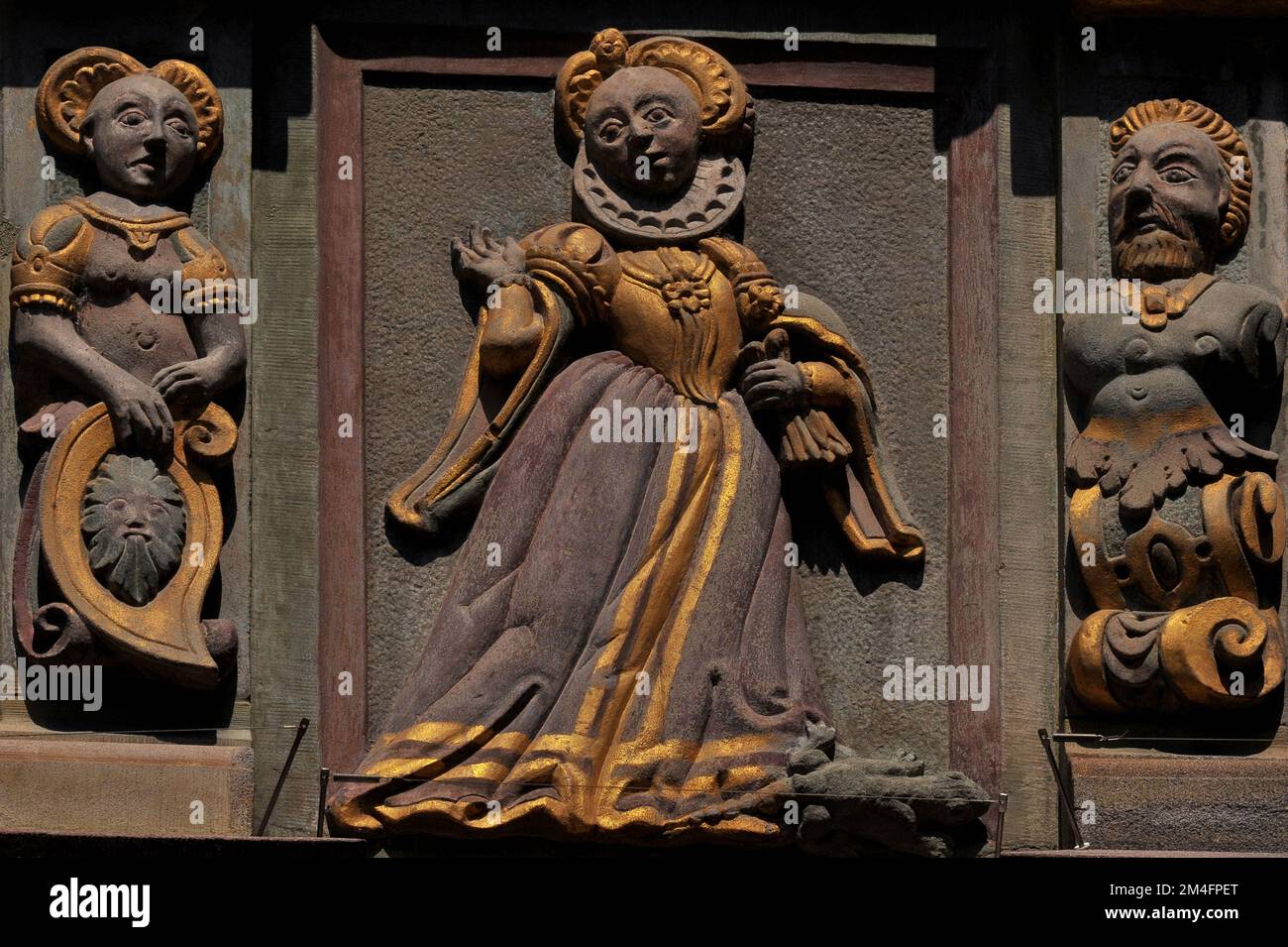 Dame de la Renaissance dorée avec un lézard à ses pieds. Elle se déporte avec sa main droite tout en tenant une paire de gants à sa gauche. De chaque côté de son stand, des grotesques mâles et femelles. Décoration de relief, sculptée en 1609, sur une fenêtre d'oriel élaborée de la Haus zum Goldenen Ochsen (Maison de l'Ox d'Or) à Vorstadt 17 dans la vieille ville de Schaffhausen, au nord de la Suisse. Banque D'Images