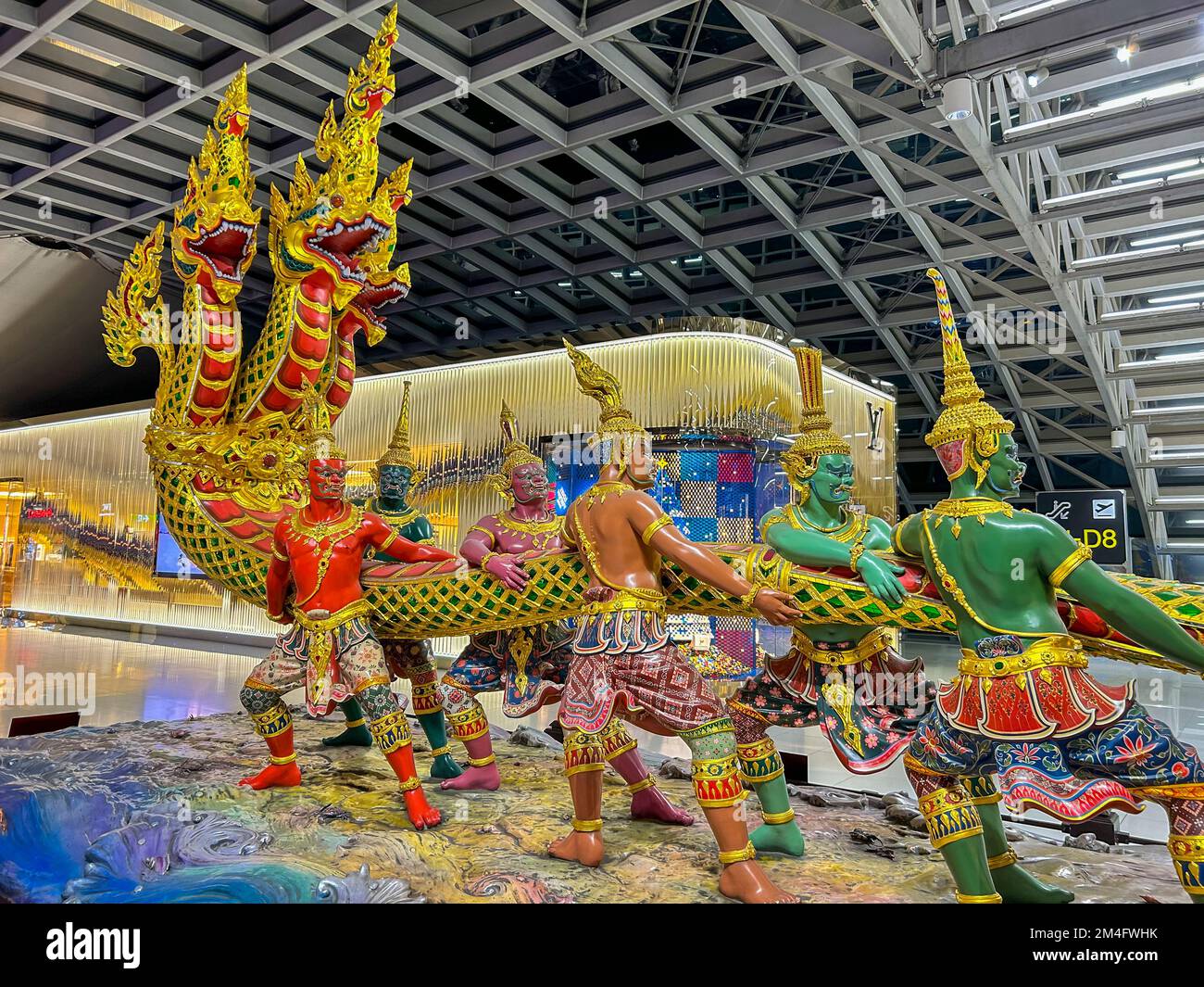 Bangkok, Thaïlande, Statue publique thaïlandaise traditionnelle avec masque, à l'intérieur de l'aéroport international, aéroport de Suvarnabhumi, Louis Vuitton, devant du magasin LVMH Banque D'Images