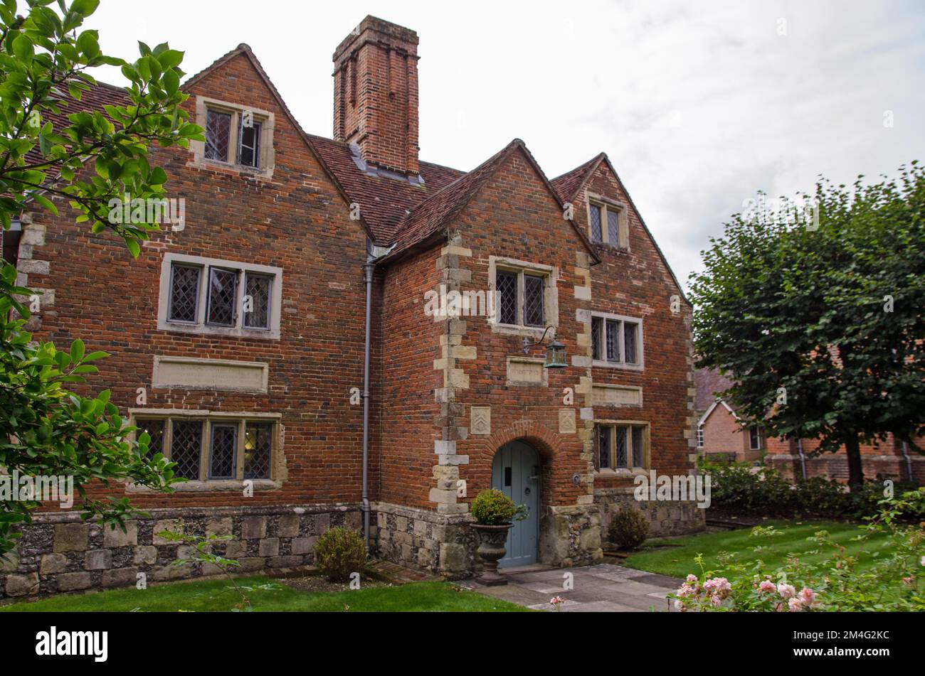Entrée à la salle commune du personnel historique de l'école publique de Winchester College dans le Hampshire. Le bâtiment en briques est entouré de jardins matures. Banque D'Images