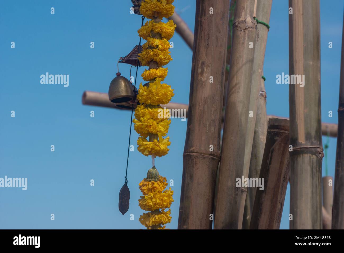 une cloche à vent avec une fleur jaune, un fond bleu ciel, un campane, une mise au point sélective Banque D'Images