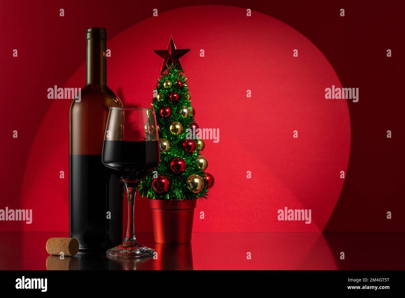 Bouteille de vin, verre de vin rouge et arbre de Noël. Avec espace de copie. Banque D'Images