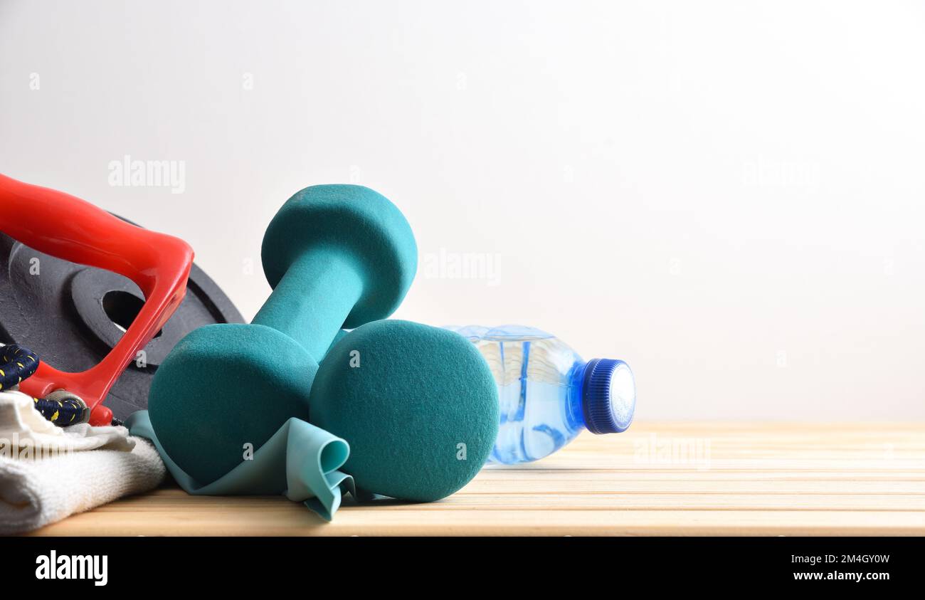 Arrière-plan sportif avec planche en bois avec serviette et bouteille d'eau et fond blanc isolé. Vue avant. Banque D'Images