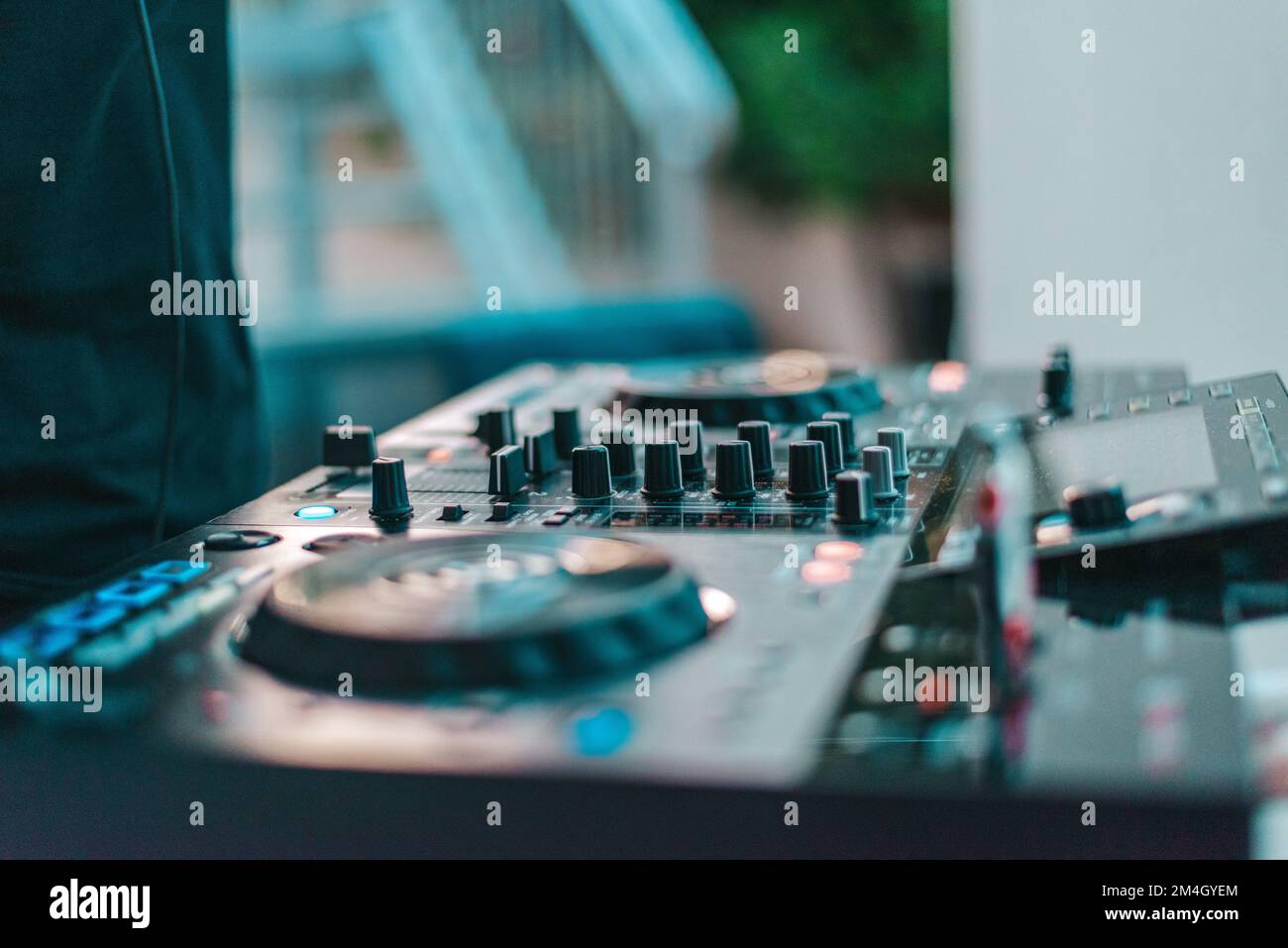 DJ joue de la musique disco avec son console dans un pub Banque D'Images