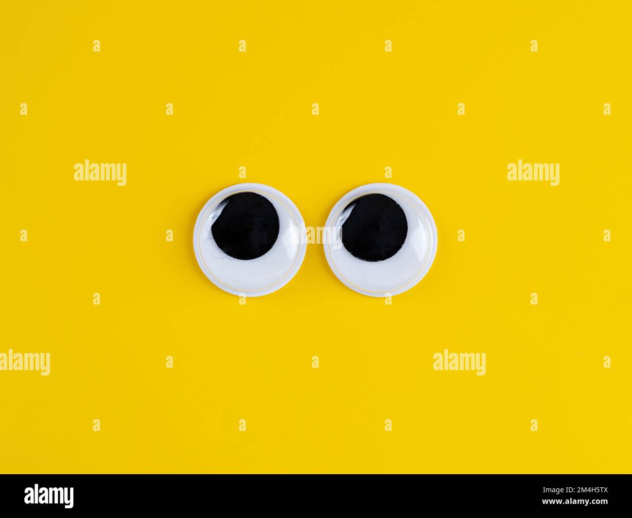 Mignon gogoogly yeux drôle isolé sur fond jaune vif copie espace logo Banque D'Images