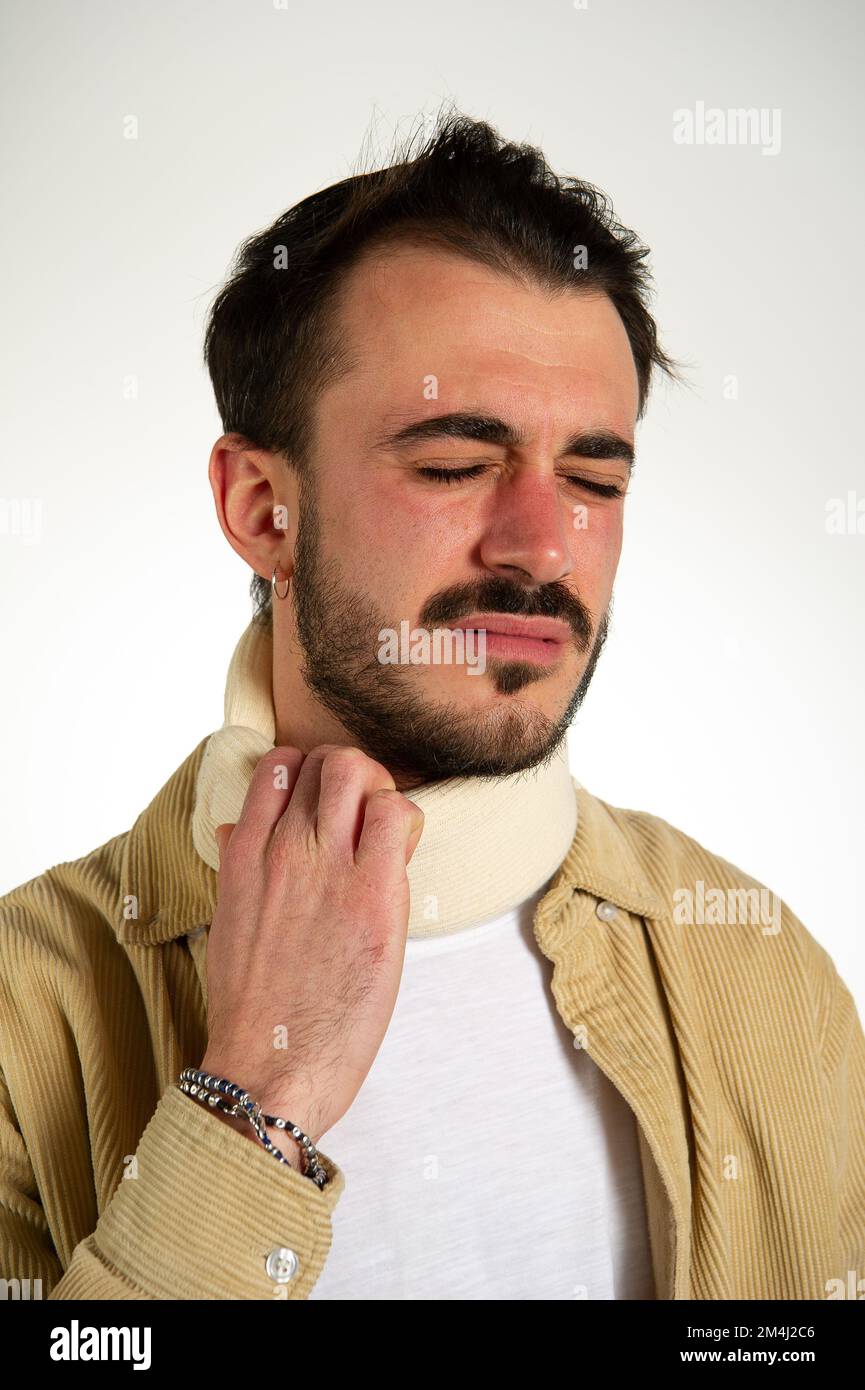 Homme avec un collier orthopédique autour de son cou et montre une grimace de la douleur, whiplash concept après un accident Banque D'Images
