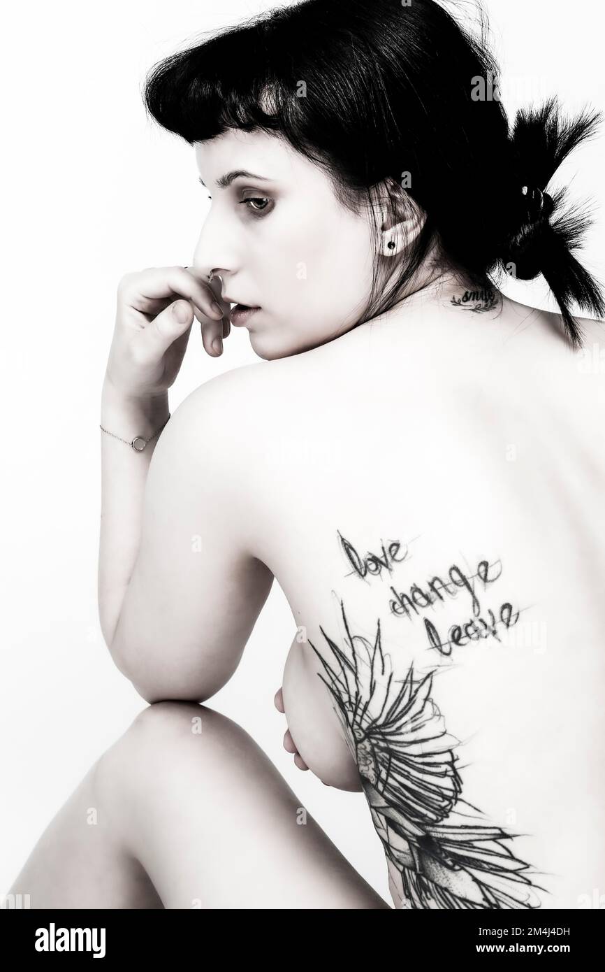Jeune femme aux cheveux noirs et au dos tatouage, fille gothique, photo noir et blanc Banque D'Images