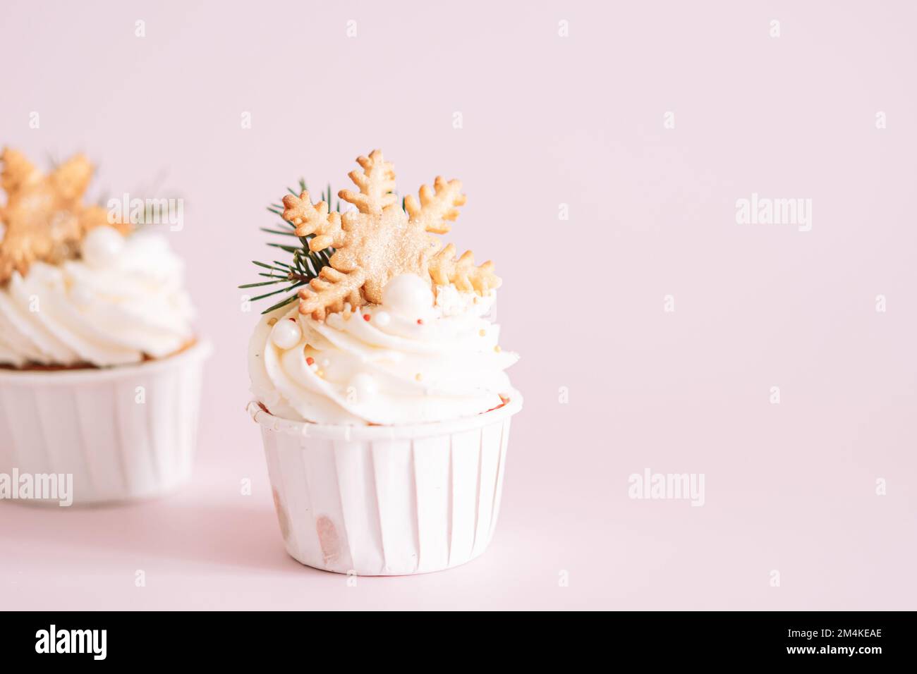 Muffins avec biscuits en forme de flocons de neige sur fond rose Banque D'Images