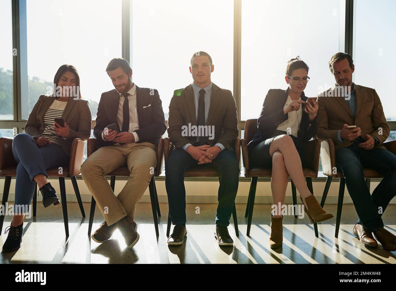 Nous étions ici pour faire progresser notre carrière. Photo en longueur d'un groupe d'hommes d'affaires assis en file d'attente en attendant d'être interviewés. Banque D'Images