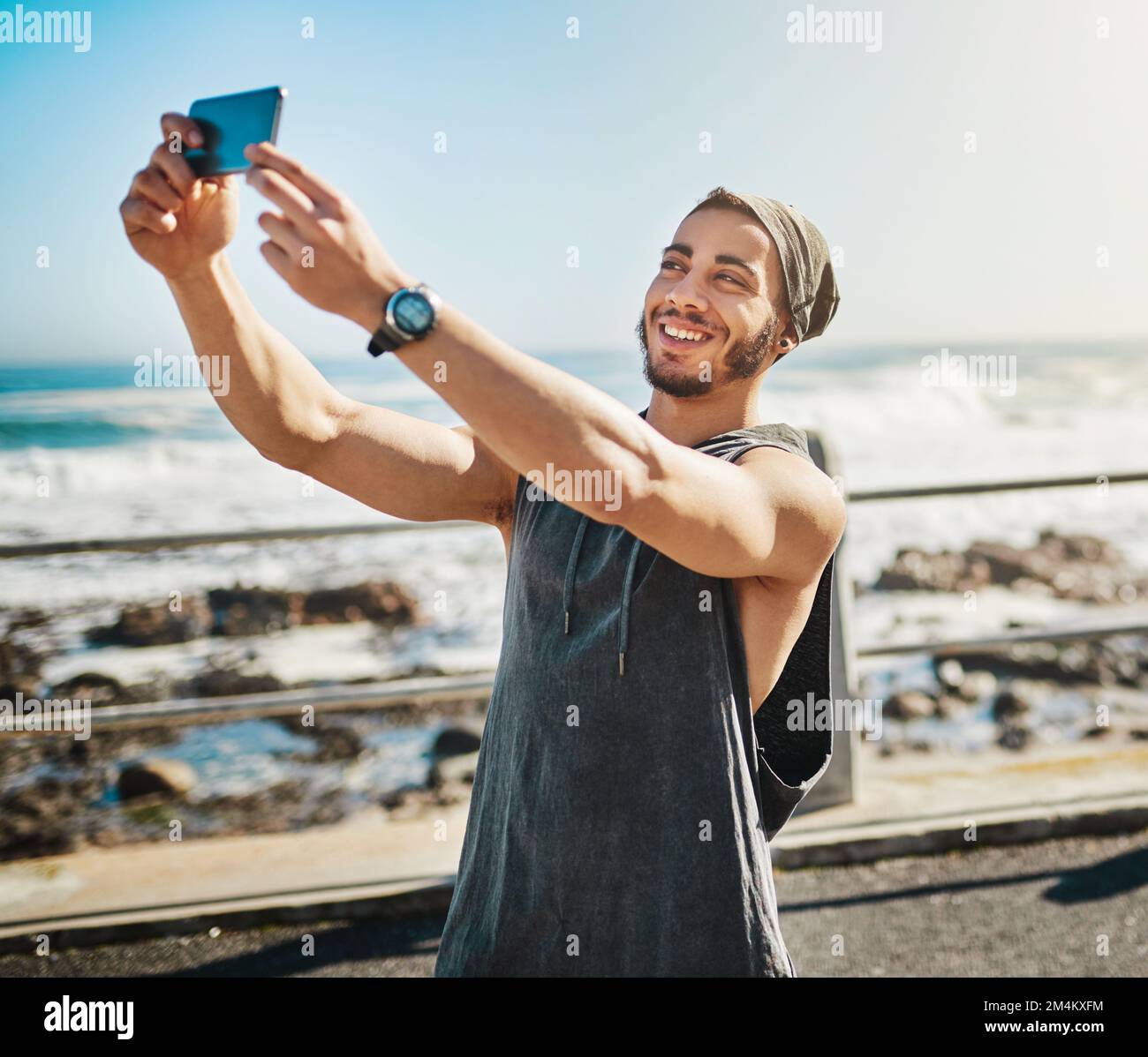 Je vous donne quelques conseils de fitness en ligne. un homme qui prend un selfie alors qu'il est en train de courir sur la promenade. Banque D'Images
