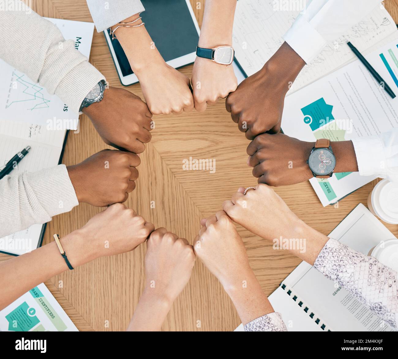 La diversité, les mains de poing et le travail d'équipe avec des documents sur la table pour la réunion d'affaires de marketing, la collaboration créative et les objectifs soutiennent la motivation. Équipe Banque D'Images