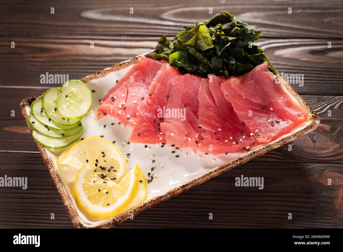 Thon sashimi, poisson cru de style japonais traditionnel. sashimi, émincé  de poisson cru, avec citron sur le plat, sur fond de table Photo Stock -  Alamy