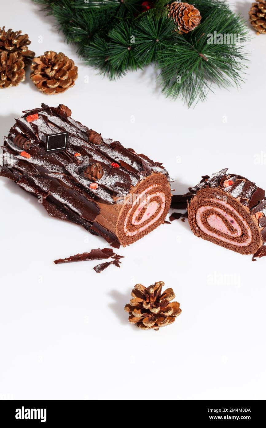 Rouleau de gâteau en éponge de chocolat en tranches avec branche d'arbre de  Noël et cônes dorés Photo Stock - Alamy