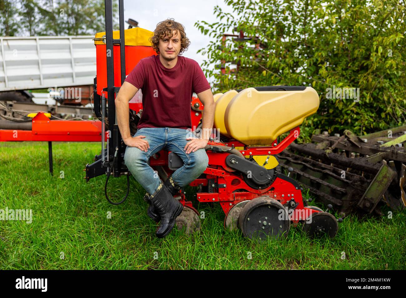 Travailleur agricole reposant sur la batteuse à l'extérieur Banque D'Images