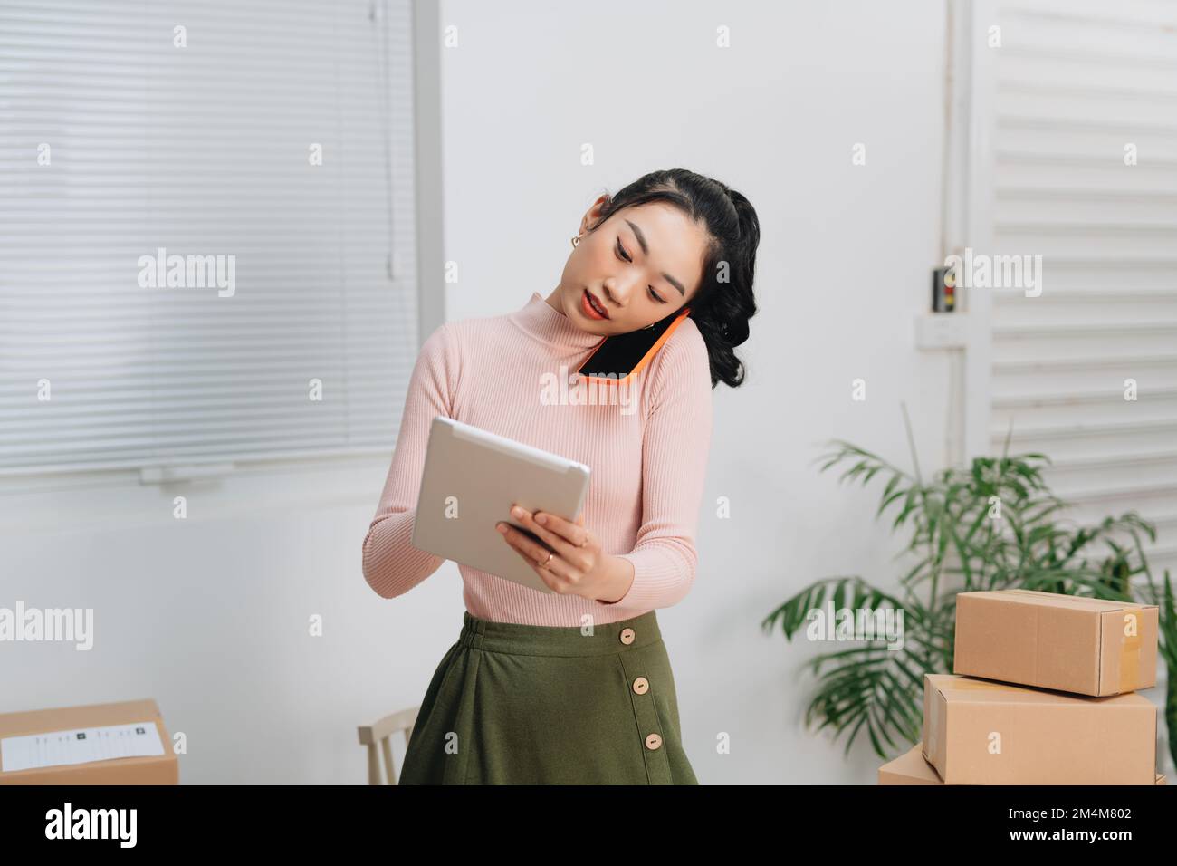 Les hommes d'affaires asiatiques acceptent les commandes en ligne par téléphone Banque D'Images