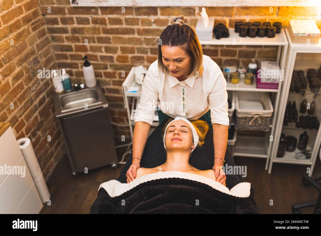 Concept de journée SPA. Femme massothérapeute donnant un massage de l'épaule et du cou à son client sur le lit DE SPA. Prise de vue en grand angle. Intérieur. Copier l'espace. Photo de haute qualité Banque D'Images